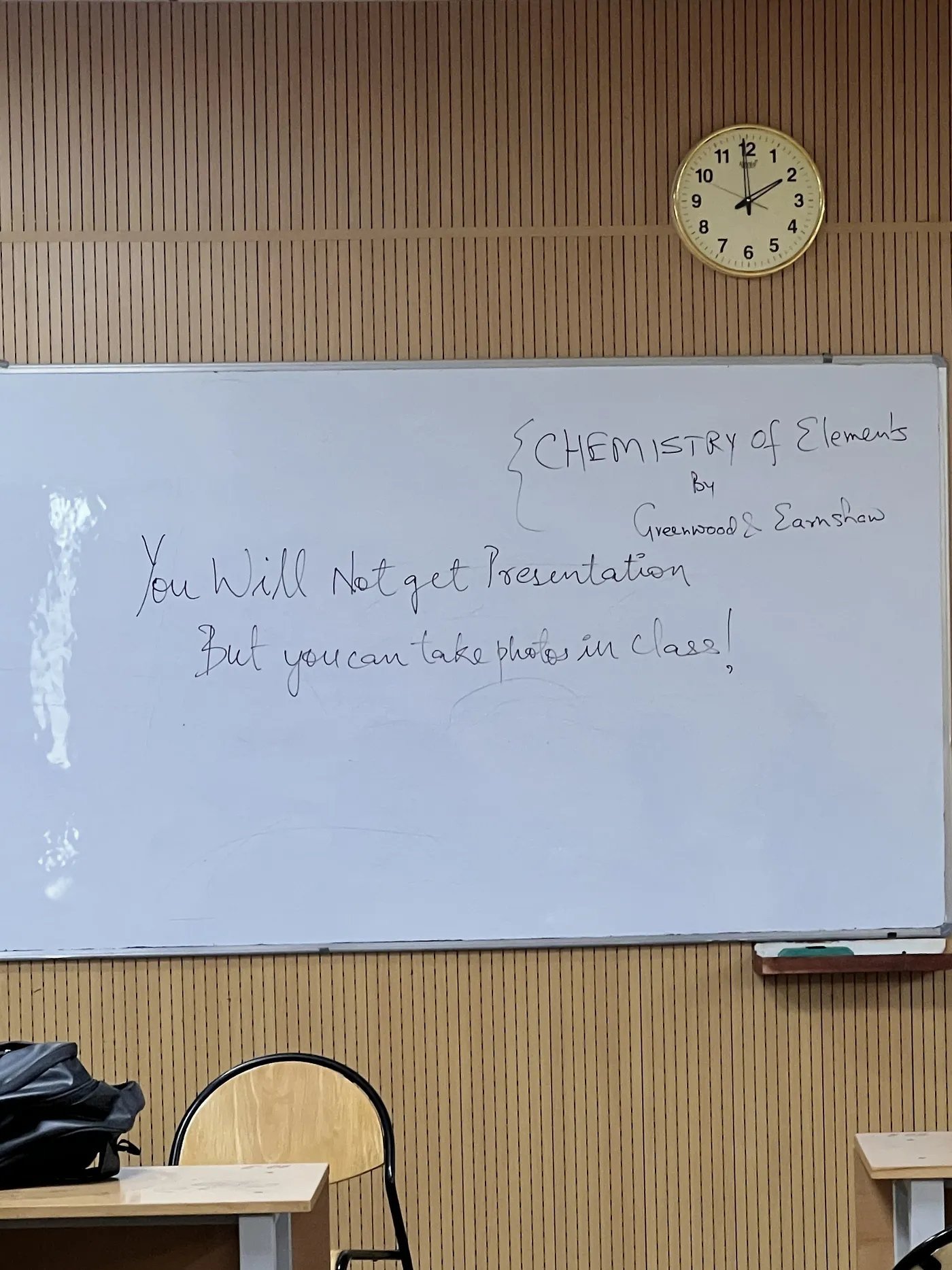 A classroom whiteboard at IIT Delhi with a handwritten note that reads ‘You will not get presentation, but you can take photos in class.’